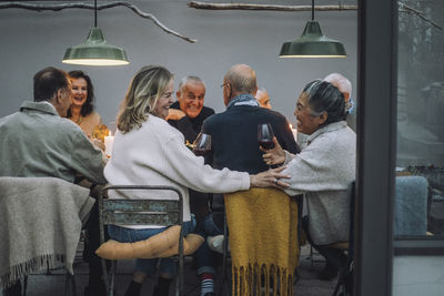 Happy retired women enjoying together with friends at dinner party