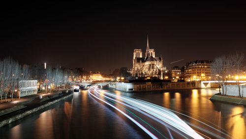 View of illuminated bridge over river at night