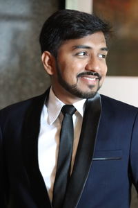 Smiling young man standing in tuxedo