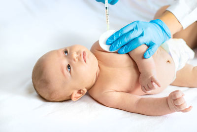 Hands of doctor giving injection to baby in clinic