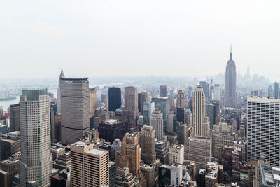 Aerial view of buildings in city against sky