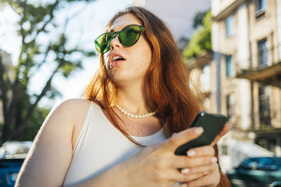 Midsection of woman using smart phone outdoors
