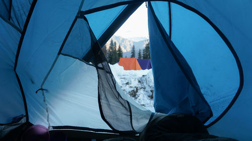 Camping with snow in blue tents on kedarnath mountain, sankari uttarakhad