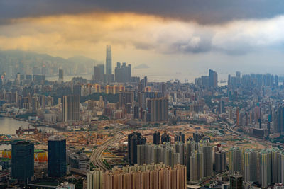 Modern buildings in city against sky during sunset