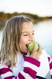 Smiling girl eating apple