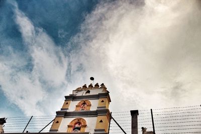 Low angle view of building against cloudy sky