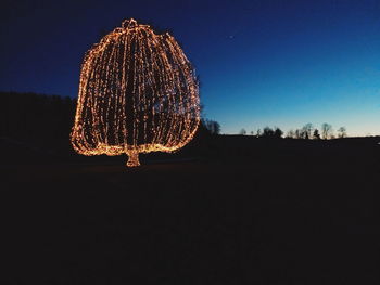 Illuminated ferris wheel against sky at night