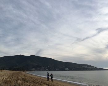 Scenic view of calm beach against mountain range