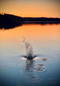 Scenic view of lake against sky at sunset