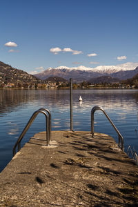 Pier over lake against blue sky