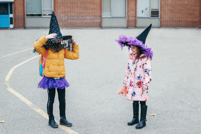Full length of girls wearing costume standing in front of building
