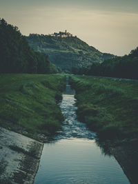 Scenic view of river amidst trees against sky