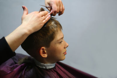 Profile portrait of a ten year old caucasian boy having his hair cut