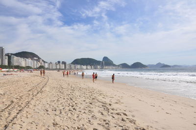 People on beach against sky