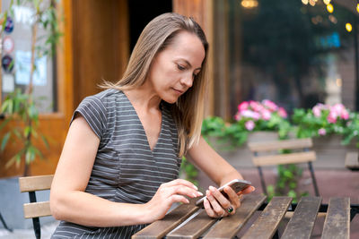 Happy successful business lady calling with mobile phone outdoors sitting