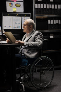 Side view of man using laptop at table