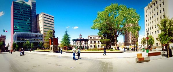 People in city against blue sky