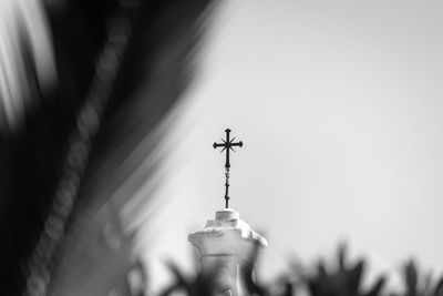 Low angle view of cross on building against sky