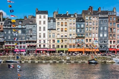 Boats moored in canal against buildings in city