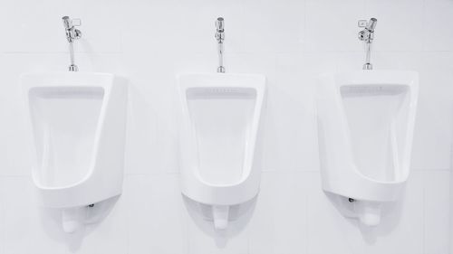 White urinals on white wall at restroom