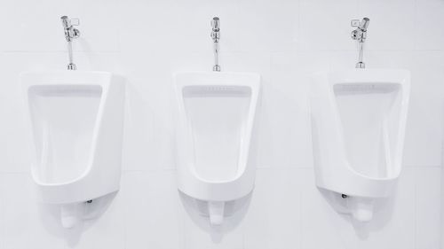 White urinals on white wall at restroom