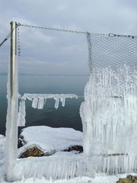 Close-up of snow on sea against sky