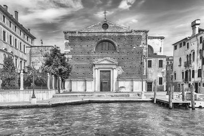 Canal amidst buildings against sky in city