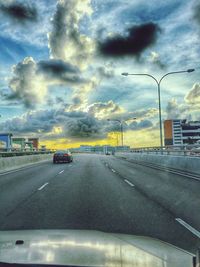 Car on road against cloudy sky