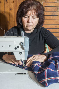 Portrait of mature woman sitting in front of machine