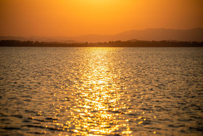 Scenic view of sea against orange sky