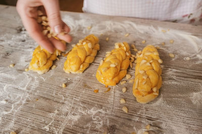 Cropped image of hand making breads on table