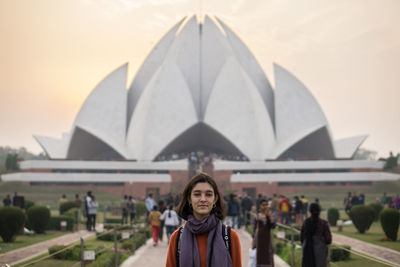 Portrait of woman standing against building