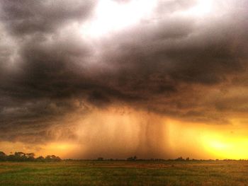 Scenic view of field against cloudy sky