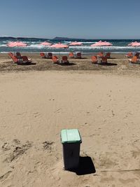 Deck chairs on beach against clear sky