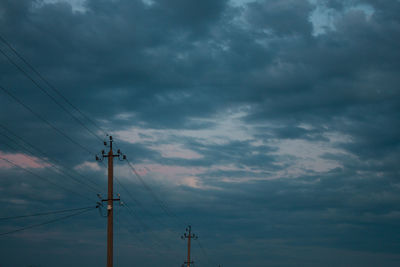 Low angle view of electricity pylon against sky