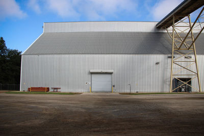 Industrial building on field against sky