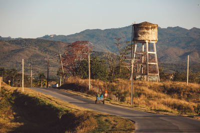 Scenic view of road leading towards mountain against sky