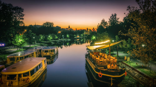 Boats moored in river at night