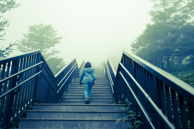 Low angle view of man walking on footbridge