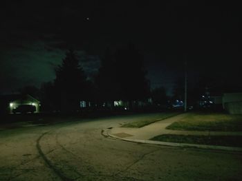 Road by trees at night