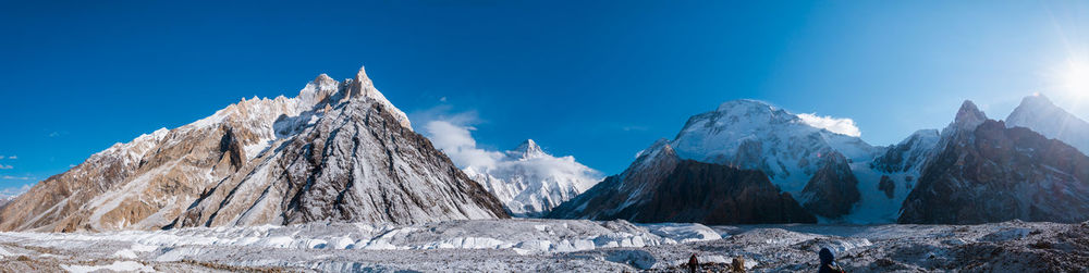 Panoramic view of snowcapped mountains against blue sky