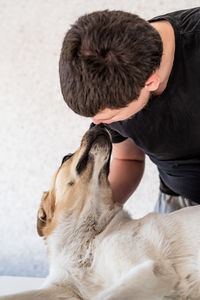 Close-up of man with dog sitting at home