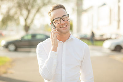 Portrait of young man using smart phone in city