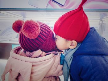 Sibling embracing during winter