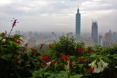 View of cityscape against cloudy sky