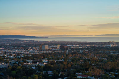 Aerial view of cityscape against sky during sunset