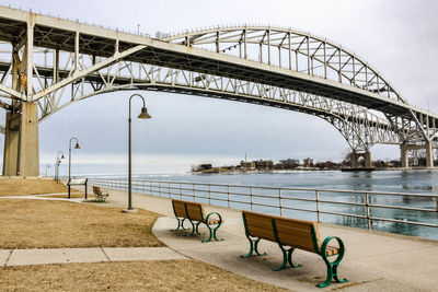 Bridge over river in city against sky