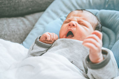 Cute baby lying on bed at home