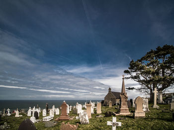 Cemetery by sea against sky