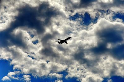 Low angle view of silhouette bird flying against sky